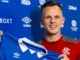 Lawrence Shankland holding a Rangers FC shirt after he signed on with the club.
