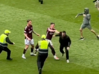 Lawrence Shankland of Hearts pushes a pitch invader during Celtic's 3-1 win over the Jambos at Celtic Park in the Scottish Premiership.