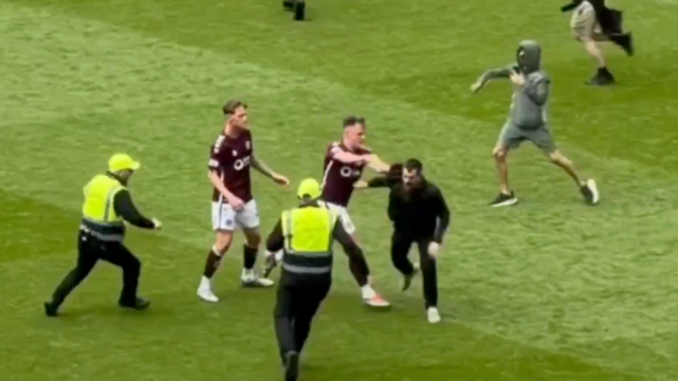Lawrence Shankland of Hearts pushes a pitch invader during Celtic's 3-1 win over the Jambos at Celtic Park in the Scottish Premiership.